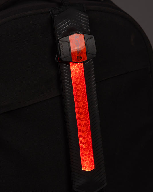 Backpack with a reflective red strip on a dark background