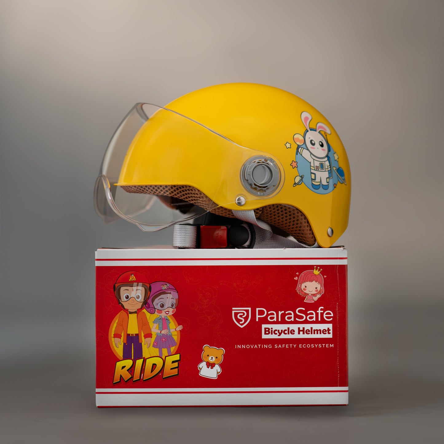 ParaSafe Yellow bicycle helmet with cartoon designs on a red 'ParaSafe' box against a gray background