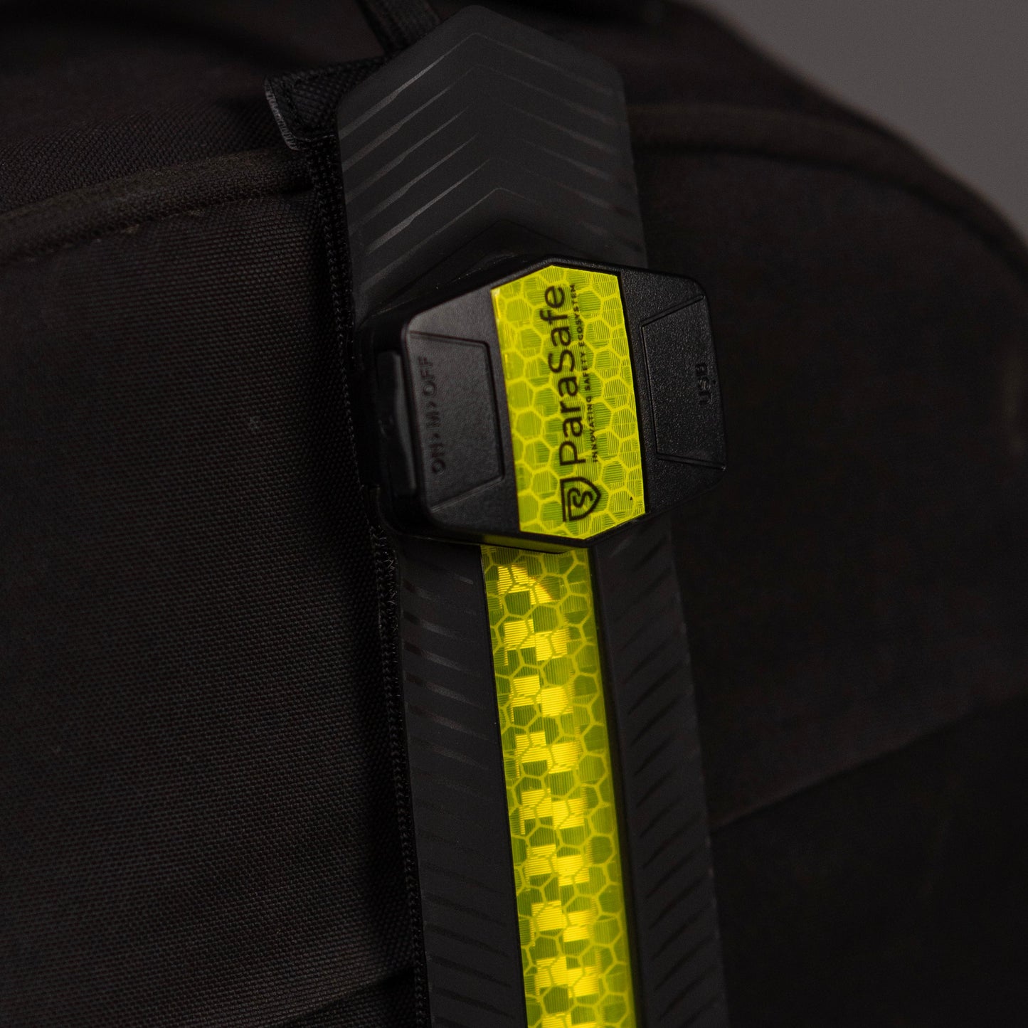Black backpack with Green ParaSafe strip on a dark background