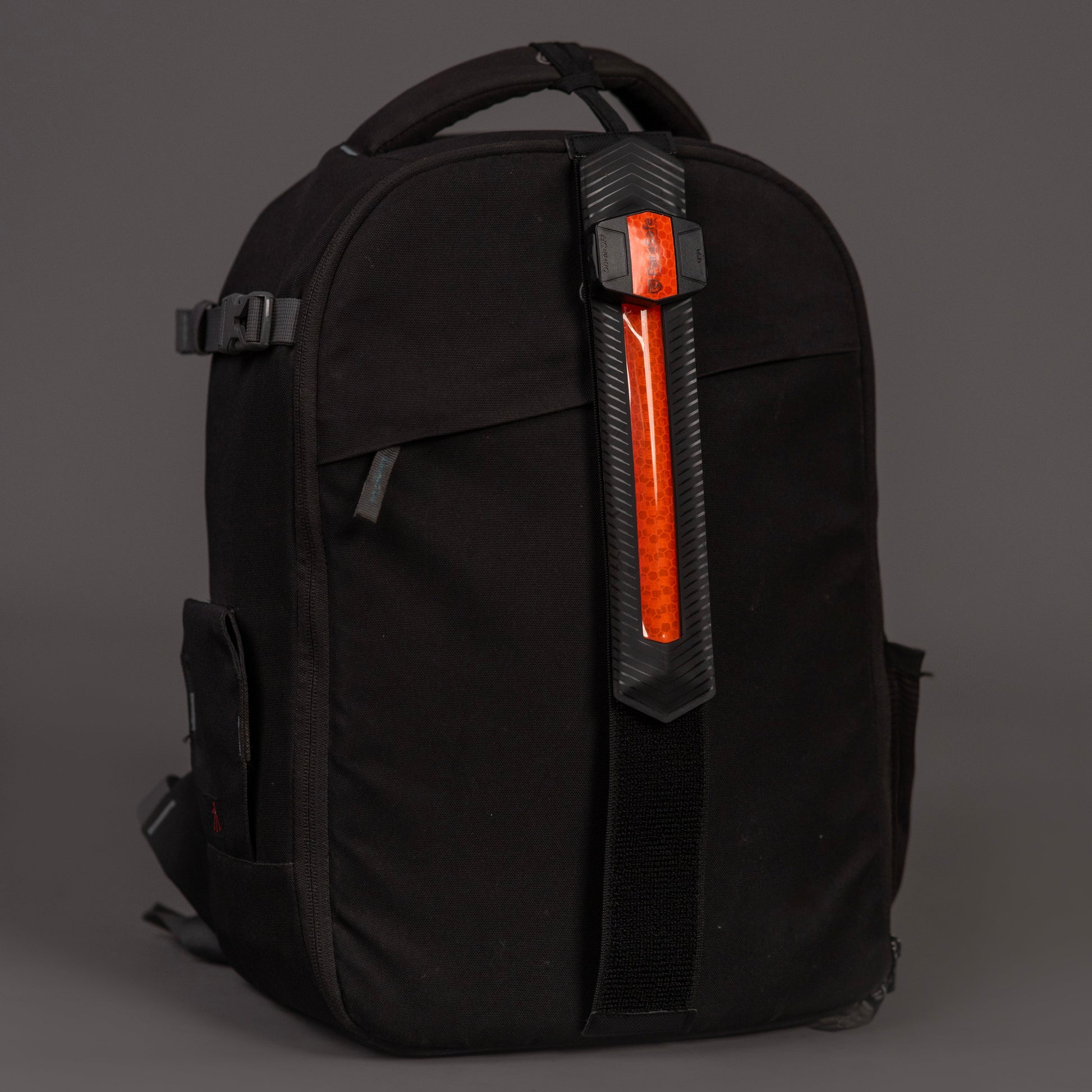 Black backpack with red ParaSafe LED wearable strip a gray background